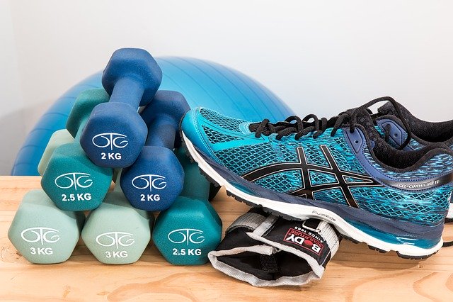 Image of dumbells and shoes on article on top fitness apps