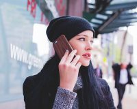 Image of a woman on the phone on article heating student accommodation