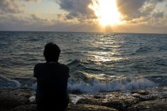 Image of man looking out to sea on how to cope with homesickness abroad