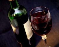 Image of a bottle of wine and a glass of red wine on article on weirdest university courses